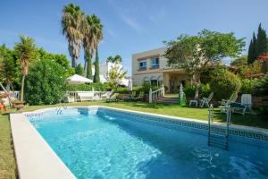 a swimming pool in front of a house at 4 bedrooms villa with sea view private pool and furnished terrace at Sanlucar de Barrameda 2 km away from the beach in Sanlúcar de Barrameda