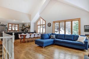 a living room with a blue couch and a table at Chalets Alpins- 4 Chemin des Montagnards in Stoneham