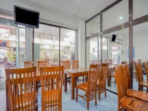 a dining room with a table and chairs and windows at SPOT ON 90110 A1 Pakis Argosari in Surabaya