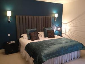um quarto com uma cama grande e paredes azuis em Fishmore Hall Hotel and Boutique Spa em Ludlow