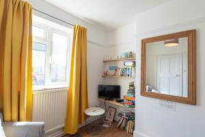 a living room with a mirror and a television at Avocet House in Wells next the Sea