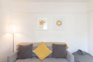 a living room with a couch with yellow pillows at Avocet House in Wells next the Sea