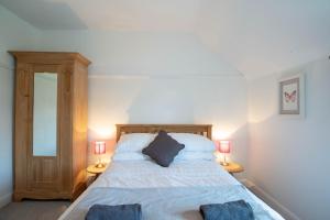 a bedroom with a large bed with two lamps at Avocet House in Wells next the Sea