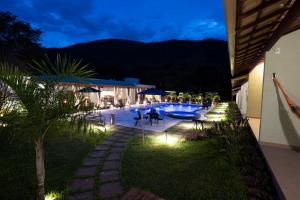 un patio trasero con piscina por la noche en Pousada Cantuá en Serra do Cipo