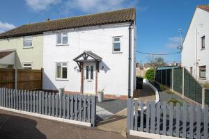 a white house with a white picket fence at Avocet House in Wells next the Sea
