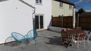 a patio with a wooden table and chairs at Avocet House in Wells next the Sea