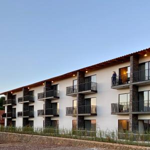 a building with balconies and a person standing on a balcony at Hotel Quinta del Bosque in Mazamitla