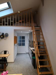 a kitchen with a staircase leading up to a loft at Cathy et eric in Beaurevoir