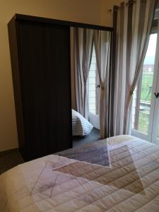 sypialnia z dużym łóżkiem i dużym lustrem w obiekcie Cathy et eric w mieście Beaurevoir