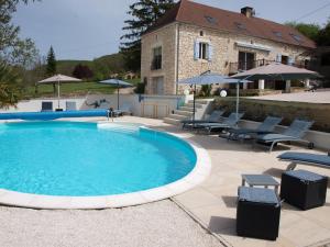 a pool with chairs and a house in the background at Domaine des Pierres Blanches - Gite La Salamandre in Carlux