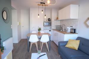 cocina y sala de estar con mesa y sofá en Appart T2 avec terrasse, parking et wifi en Angoulême