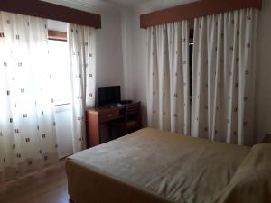 a bedroom with a bed and a desk and a window at Nossa Senhora do Pranto in Ferreira do Zêzere +6 photos