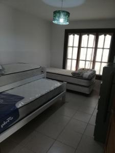 2 camas en una habitación con 2 ventanas en La Moradita en Necochea