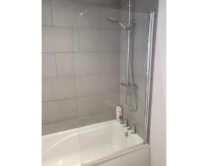 a bathroom with a shower and a white tub at Townhouse @ Nicholls Street Stoke in Stoke on Trent