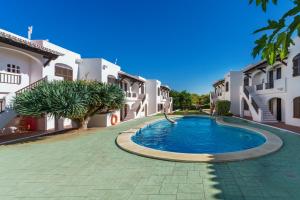 a swimming pool in the middle of some buildings at Apartamentos Posidonia in Son Parc