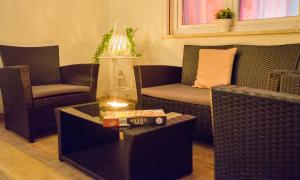 un soggiorno con tavolo e sedie in vimini di Mini Appartamento con giardino in centro a Catanzaro