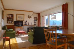 a living room with a couch and a dining room table at Central & Spacious, Richemont in Crans-Montana