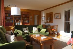 a living room with green couches and a coffee table at Central & Spacious, Richemont in Crans-Montana