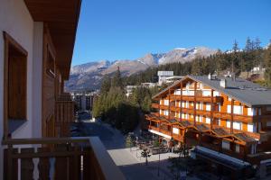 a view of a building with mountains in the background at Central & Spacious, Richemont in Crans-Montana
