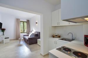 a white kitchen and living room with a couch at Elia Portou Luxury Residence in Chania