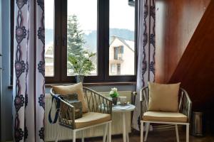 two chairs and a table in front of a window at Czarna Willa in Zakopane
