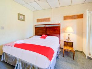 a bedroom with a large bed and a lamp on a table at OYO Hotel Drumright I-44 OK in Drumright