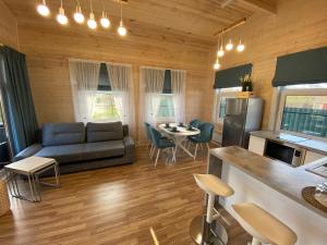 a kitchen and living room with a couch and a table at Diamant Village in Denezhnikovo