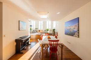 a living room with a piano and a table and chairs at River house in Porto