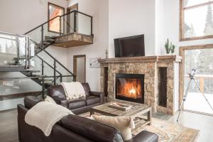 a living room with a couch and a fireplace at Wildridge Chalet in Big Sky