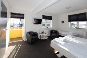 Skagen Hotel Annex في سكاغن: غرفة بسرير وكرسيين وطاولة