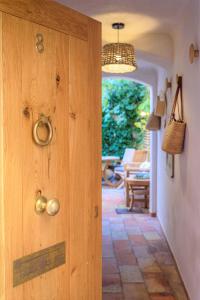 Cette chambre dispose d'une porte en bois et d'une terrasse. dans l'établissement Maison Magdeleine, à Saint-Tropez