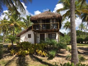 uma casa na praia com palmeiras em Pousada Mar dos Algodões - Praia de Algodões em Praia dos Algodões