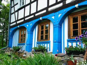 a blue and white house with windows and flowers at Dom Przysłupowy Educare -Agroturystyka Slow Food in Świeradów-Zdrój