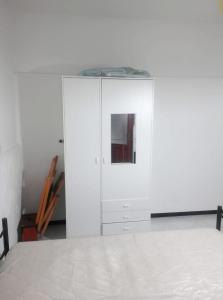 um armário branco num quarto com uma cama em One bedroom appartement at Carloforte 1 km away from the beach em Carloforte