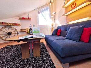 a living room with a blue couch and a table at Ferienhaus Alexandra in Nesselwang