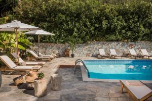 a swimming pool with lounge chairs and an umbrella at La Signora Hotel in Lourdhata