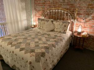 a bedroom with a bed with a brick wall at The Palace Hotel in Port Townsend