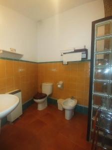 a bathroom with two toilets and a sink at La Troje Oropesana in Oropesa