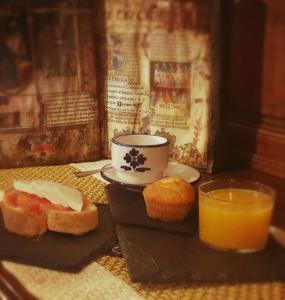 un desayuno con pan, zumo de naranja y un cupcake en La Troje Oropesana, en Oropesa