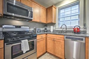 una cocina con electrodomésticos de acero inoxidable y armarios de madera en Inviting Salem Apartment Near Waterfront and Museums, en Salem