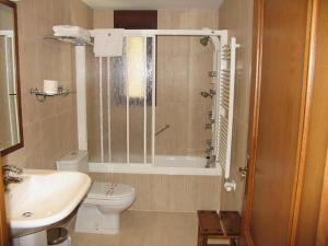 a bathroom with a shower and a toilet and a sink at Hotel Villa Russell in Torla