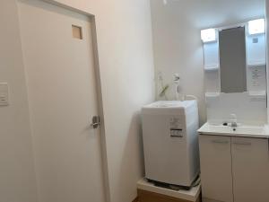 a bathroom with a sink and a washing machine at NEW Open かりゆしハウスコザ 本島中部の沖縄市パークアベニュー近くのレトロな街で快適ステイ in Okinawa City +18 photos