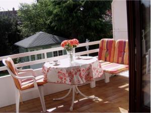 einen Tisch und Stühle mit einer Vase aus Blumen auf dem Balkon in der Unterkunft Exklusive Lage, sehr große Wohnung mit Gartenblick - FEWO Hämmerle Rot in Konstanz