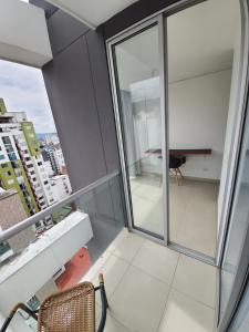balkon ze szklanymi drzwiami i biurkiem w budynku w obiekcie Amoblados Casa de Pinos Bucaramanga w mieście Bucaramanga