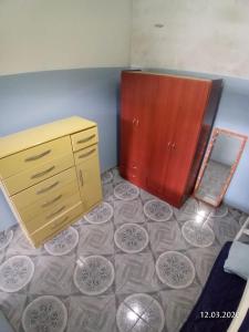 um quarto com uma cómoda e um armário com pratos no chão em Grace House em Caieiras