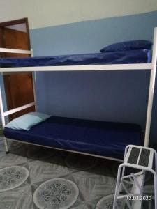 two bunk beds with blue sheets and a ladder at Grace House in Caieiras