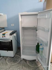 an empty refrigerator with its door open in a kitchen at Grace House in Caieiras