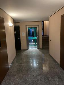 un couloir vide d'un bâtiment avec une porte dans l'établissement la nostra casa..., à Novara