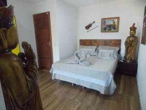 a bedroom with a bed with a swan on it at Flor de Limão Hotel Boutique in Coroa Vermelha