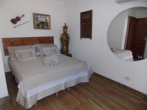 a bedroom with a bed with a large mirror at Flor de Limão Hotel Boutique in Coroa Vermelha